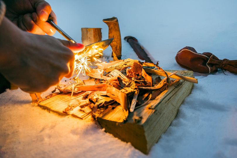 People starting camp fire