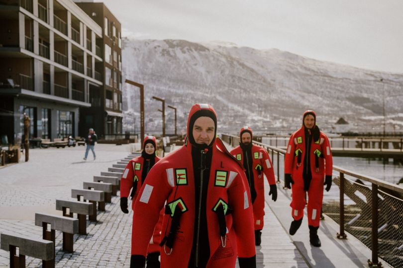 group of four people in rescue suits walking towards their floating experience