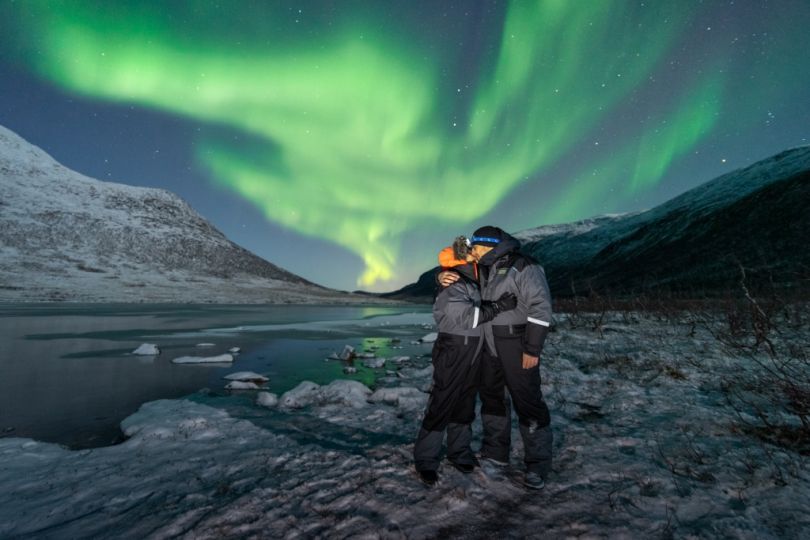 People standing under Northern lights