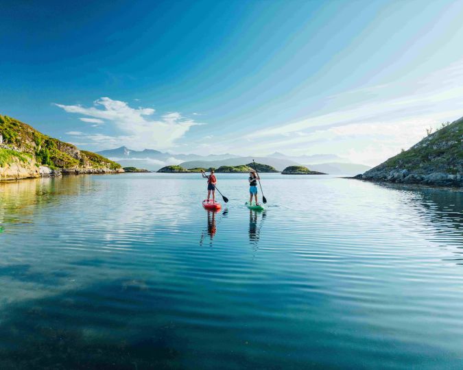 two people paddleboaring in beautiful landscapes