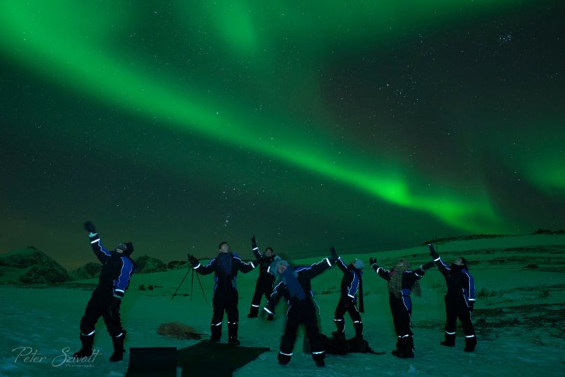 People standing under Northern Lights