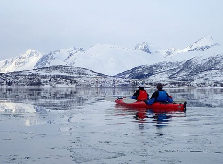 Winter kayaking in Tromso Norway with snow covered mountains