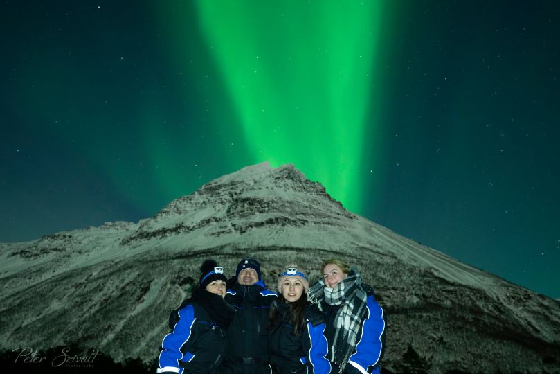 People standing under Northern Lights