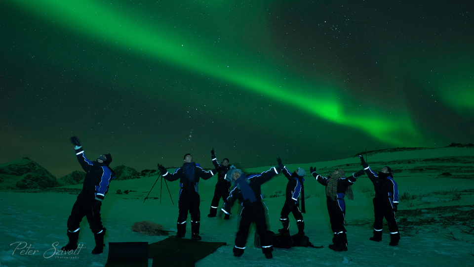 Group of people looking at Northern Lights in nature