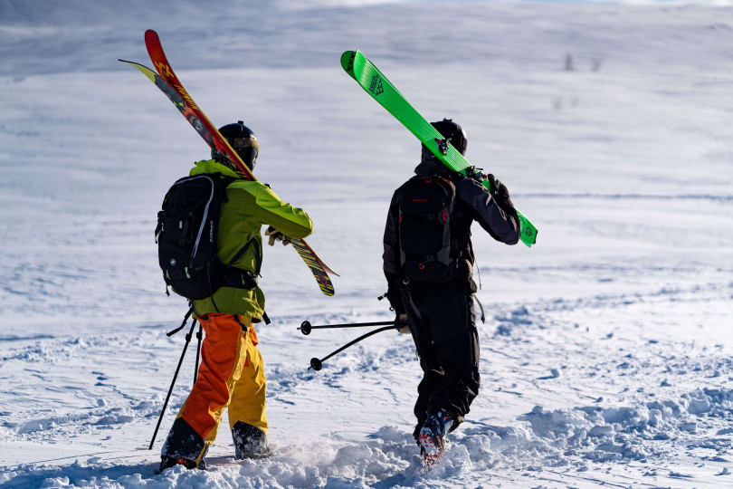 Two people dressed warmly ready to go ski