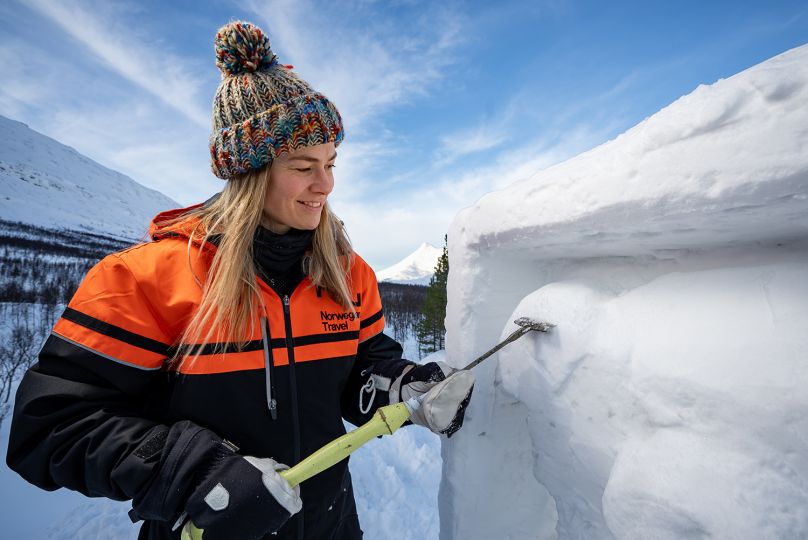 Woman carving sculpture in snow