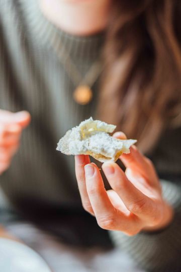 person eating flat bread with goat cheese