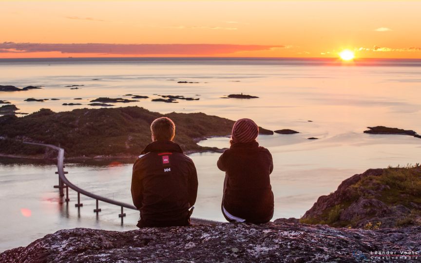 Two people sitting on the hill and watching nature