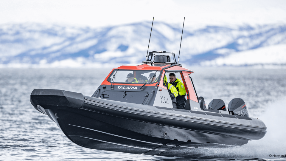 People drinig RIB boat through sea.