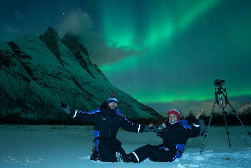 People standing under Northern Lights