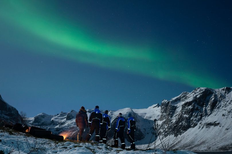 People standing under Northern Lights